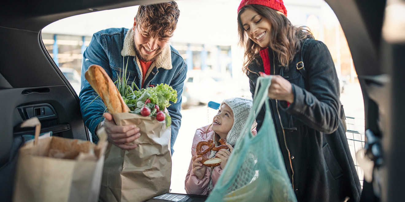 Family putting groceries in their card